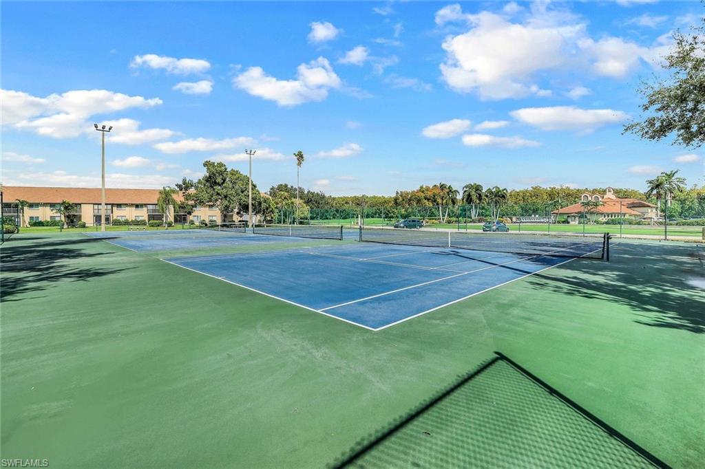 Tennis courts featuring blue and green surfaces, perimeter fencing, and overhead lighting
