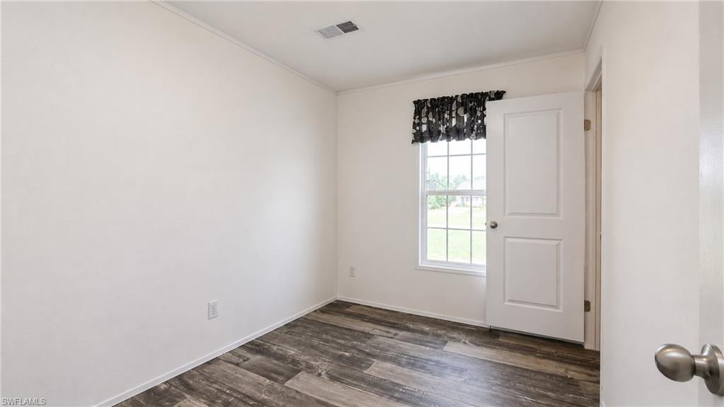 Interior room featuring wood-finish flooring and a white paneled door