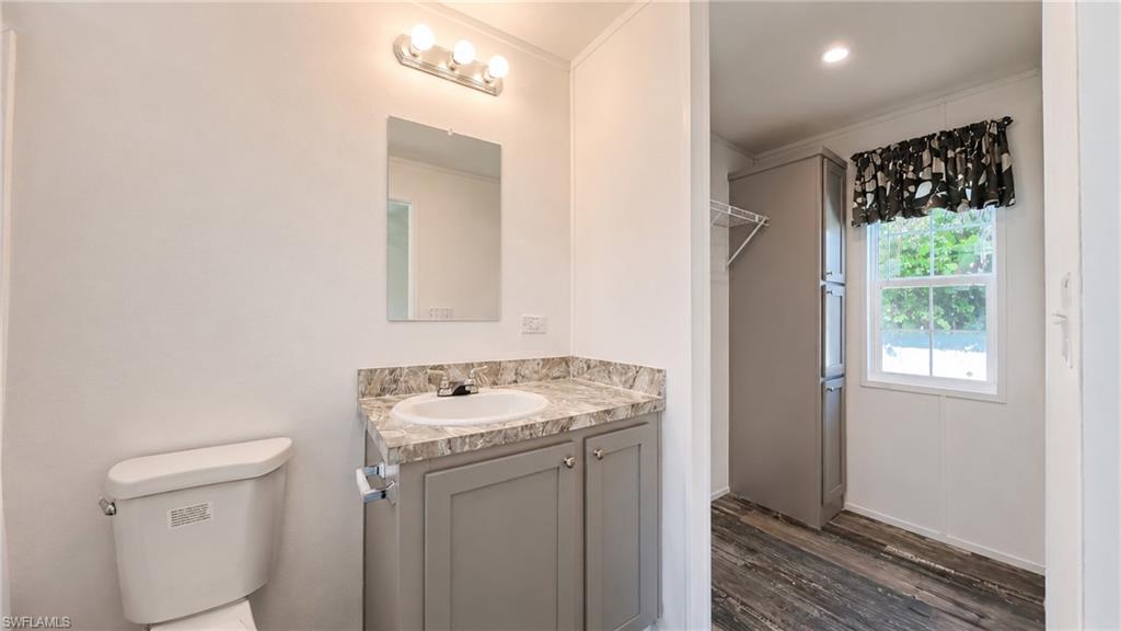 Bathroom vanity with a round sink, light-toned countertop, and gray cabinetry