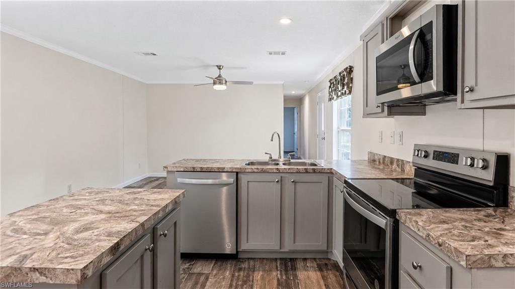 Kitchen featuring wood-finish flooring and grey cabinetry