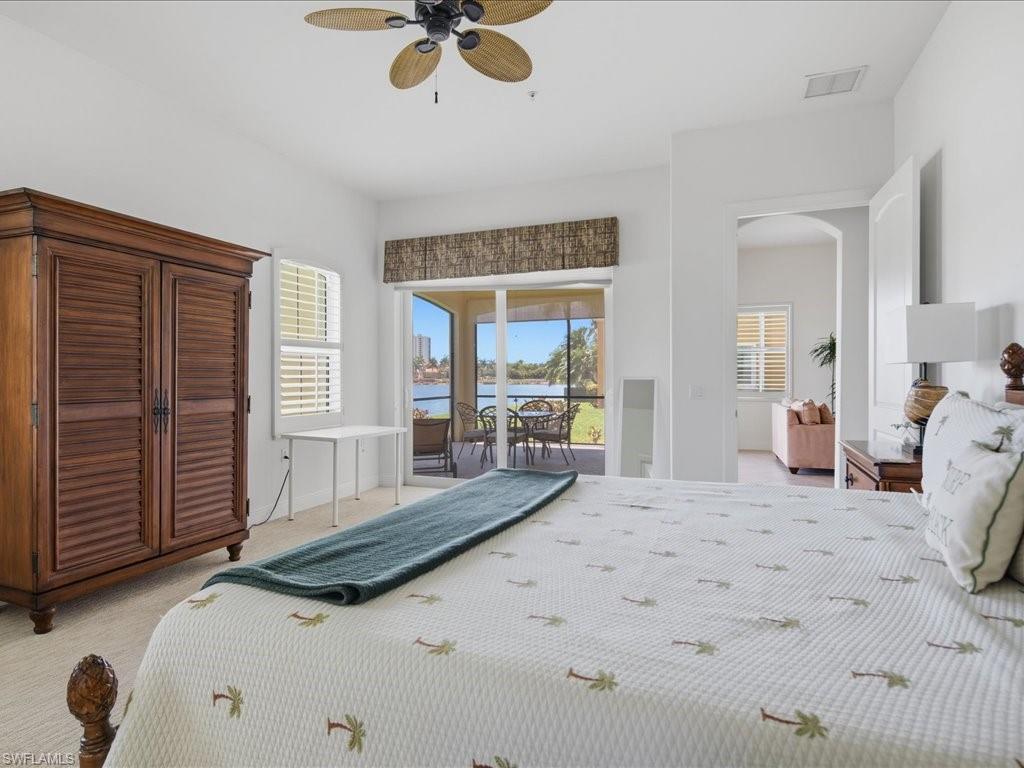Spacious interior featuring a ceiling fan, white window shutters, and a sliding glass door leading to an outdoor screened patio