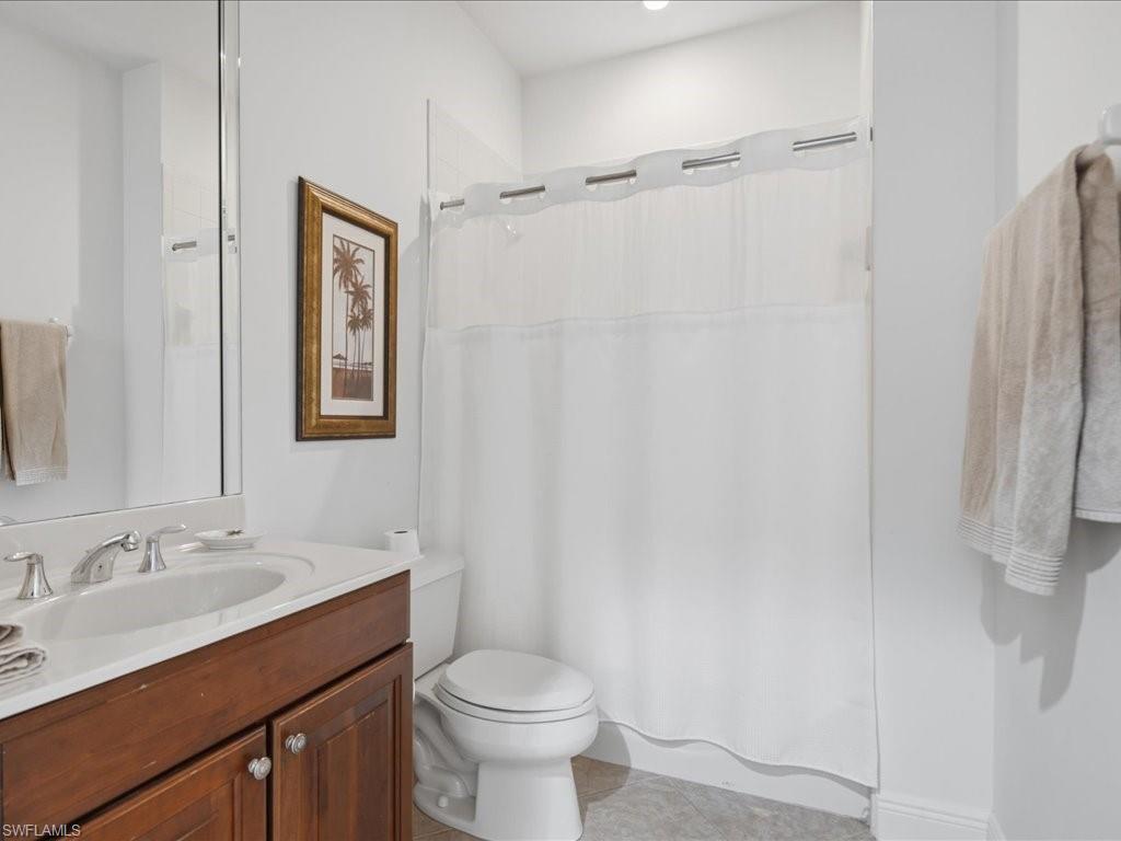 Bathroom with a cherry wood-finish vanity, white countertop, and integrated sink