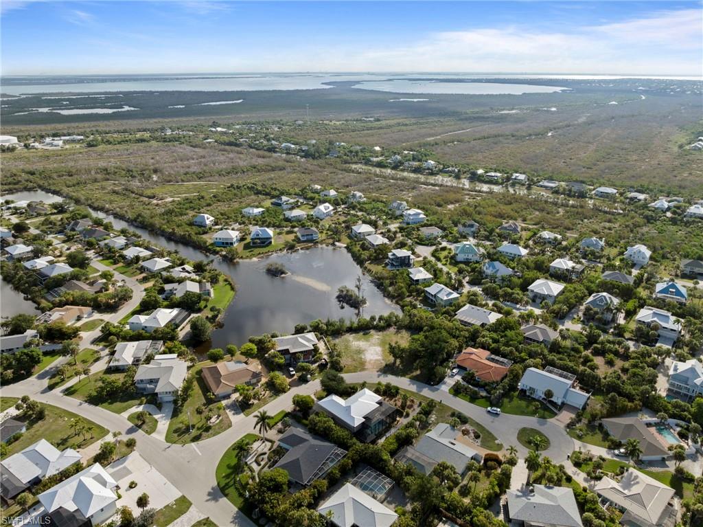 Aerial perspective showcasing a residential community with diverse architectural styles, featuring multiple properties with private swimming pools