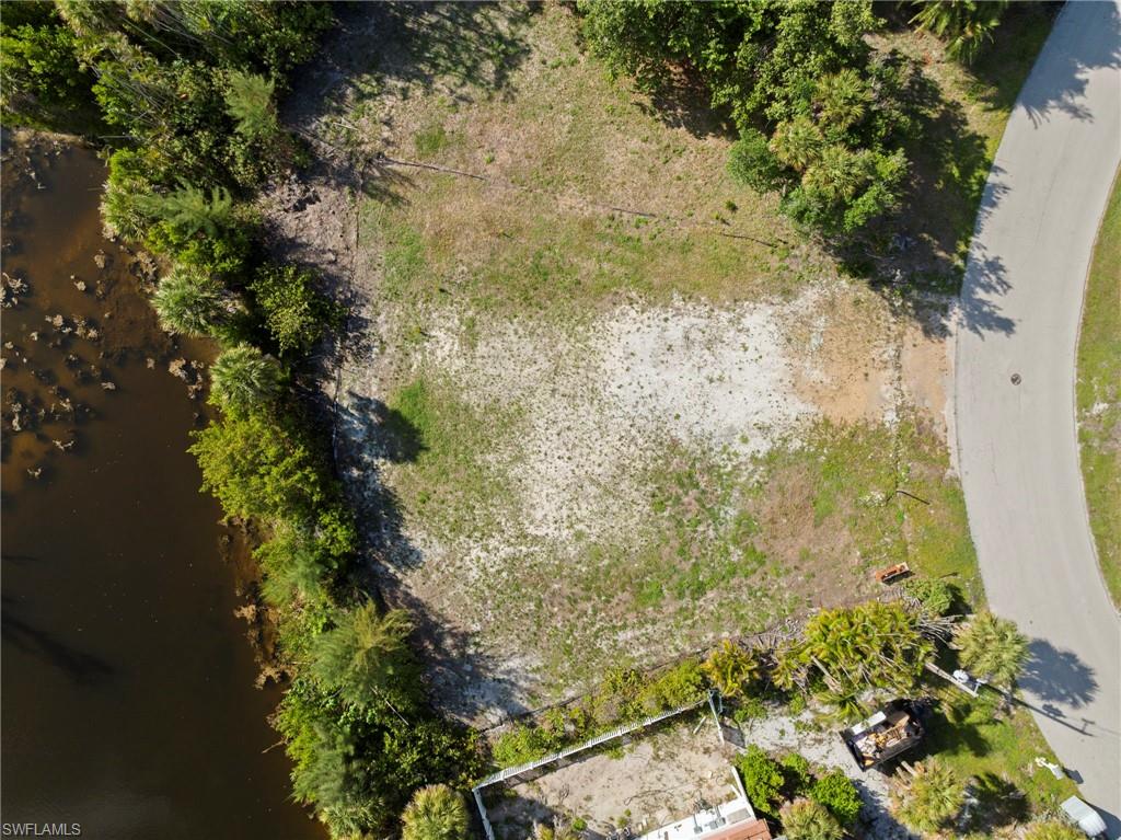 Expansive lot with a natural water feature, mature perimeter trees, and a paved road frontage