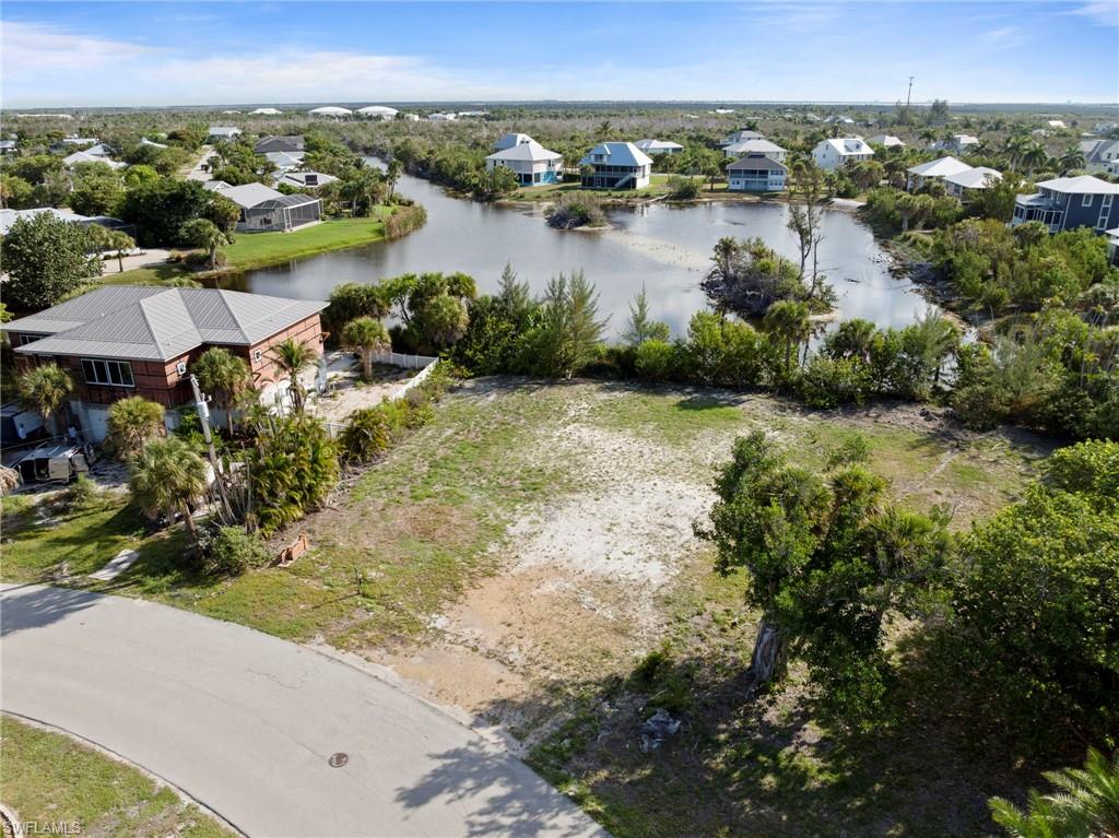 Expansive undeveloped lot featuring partial vegetation and a paved street frontage