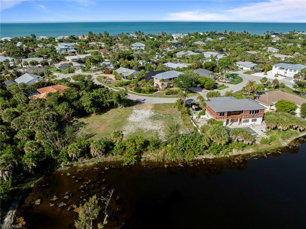 Expansive lot featuring a cleared building envelope, mature tropical landscaping, and a waterfront boundary