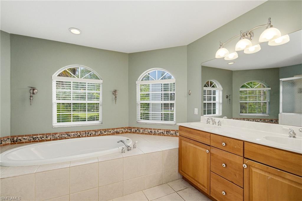 Soaking tub with tile surround and decorative mosaic border