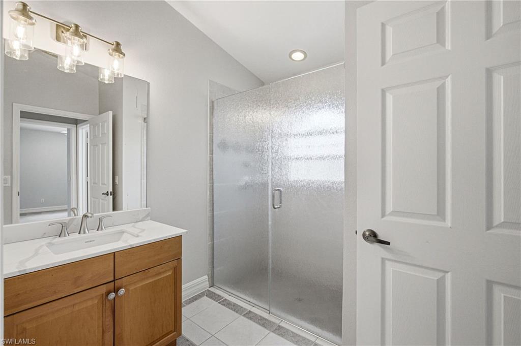 Bathroom featuring a light wood-finish vanity with a white countertop and undermount sink, brushed nickel faucet, and overhead lighting fixture