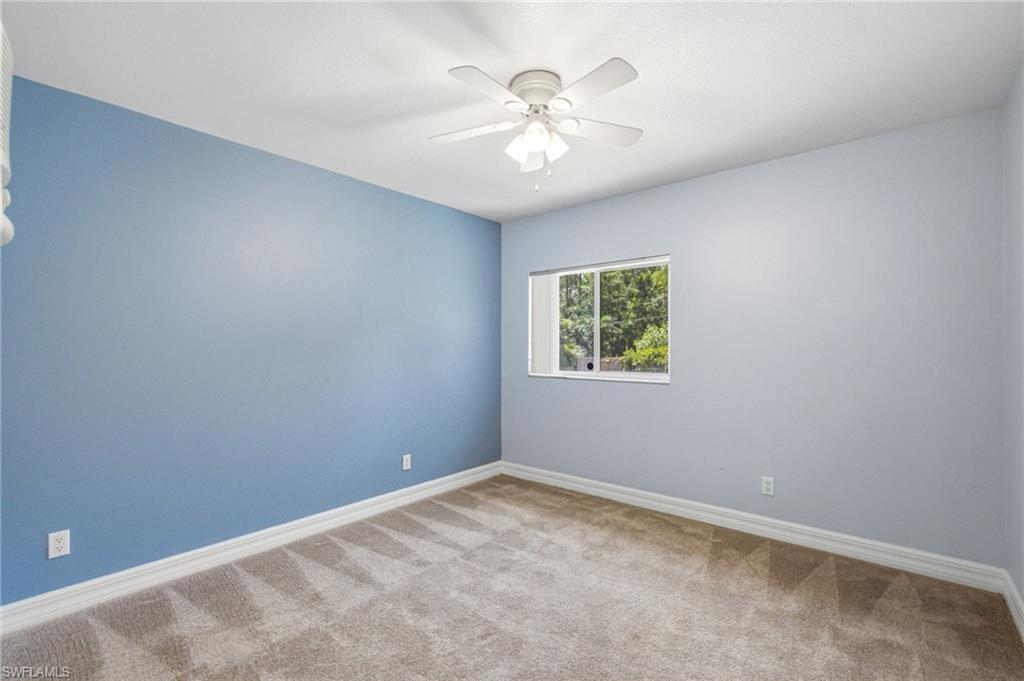 Room featuring light blue walls, neutral carpet flooring, and white baseboards
