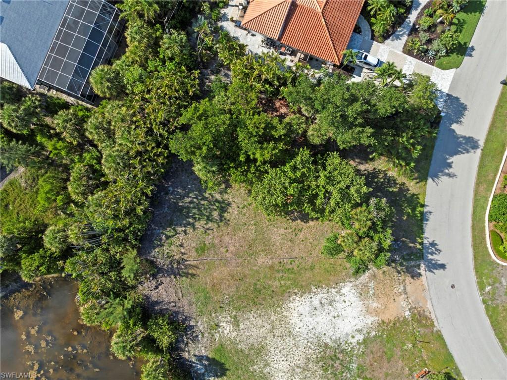 Expansive residential lot featuring mature trees and a natural water perimeter
