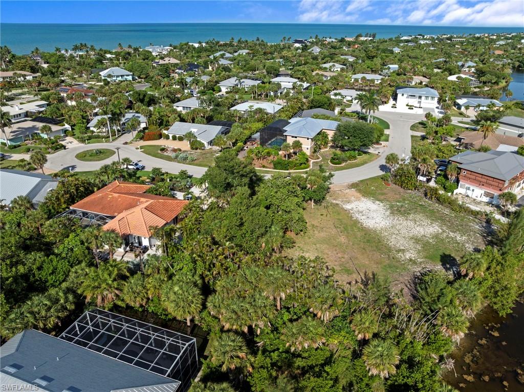 Expansive vacant lot featuring natural ground cover, mature landscaping, and water frontage
