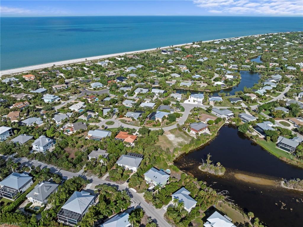 Coastal community featuring numerous homes, extensive natural landscaping, and proximity to a large body of water