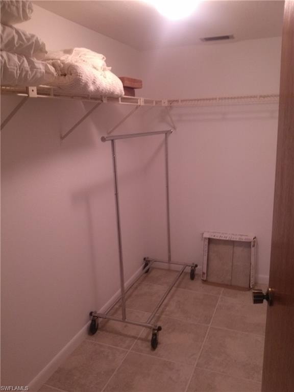 Spacious closet featuring tile flooring