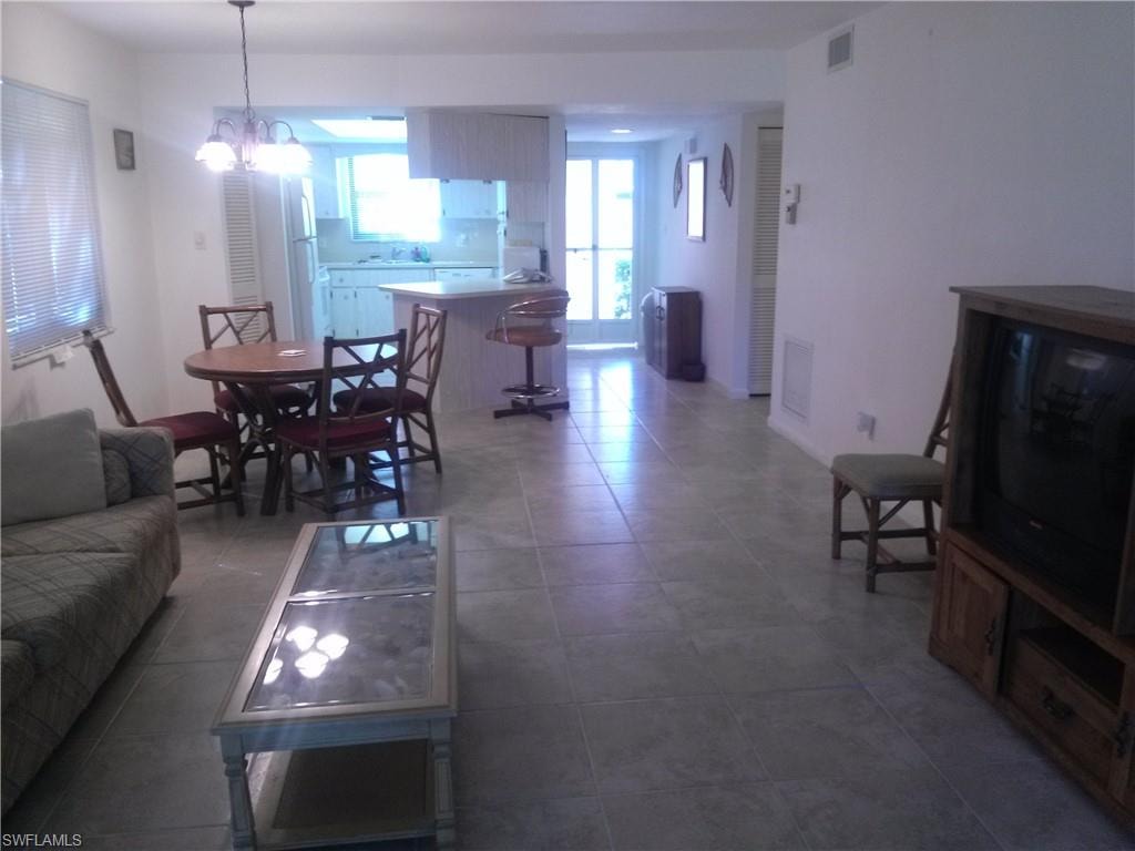 Tiled living room with a notable chandelier and sink