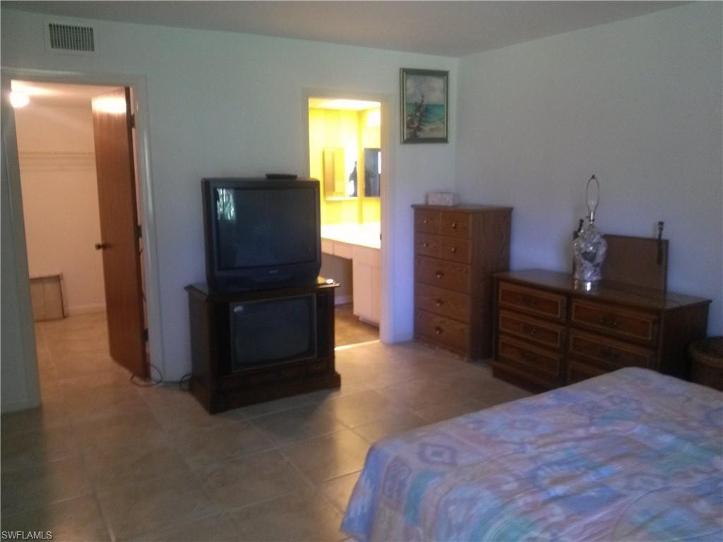 Tiled bedroom with connected bathroom, a closet, and a spacious closet