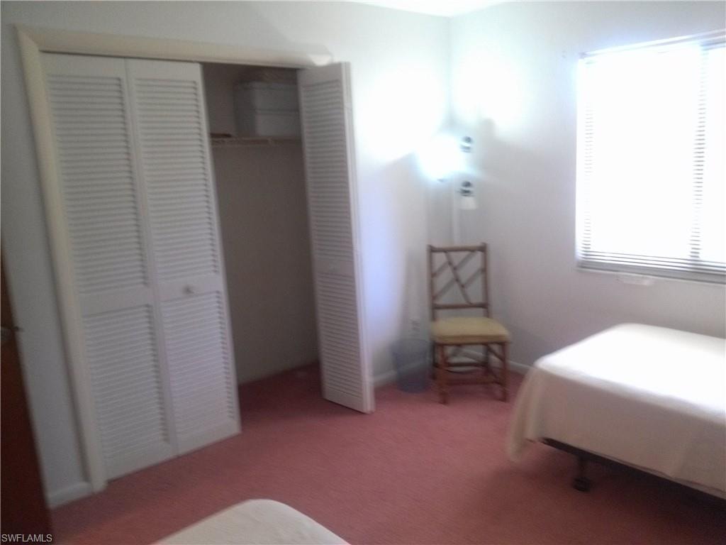 Carpeted bedroom with a closet