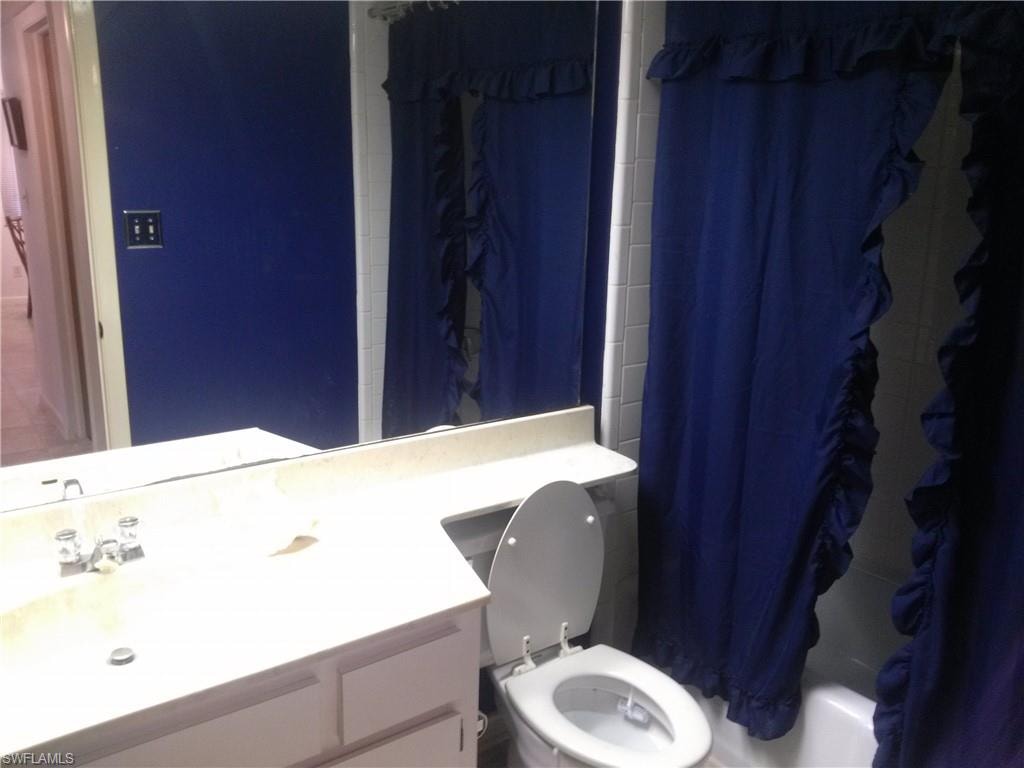 Full bathroom featuring shower / bath combo, vanity, and toilet