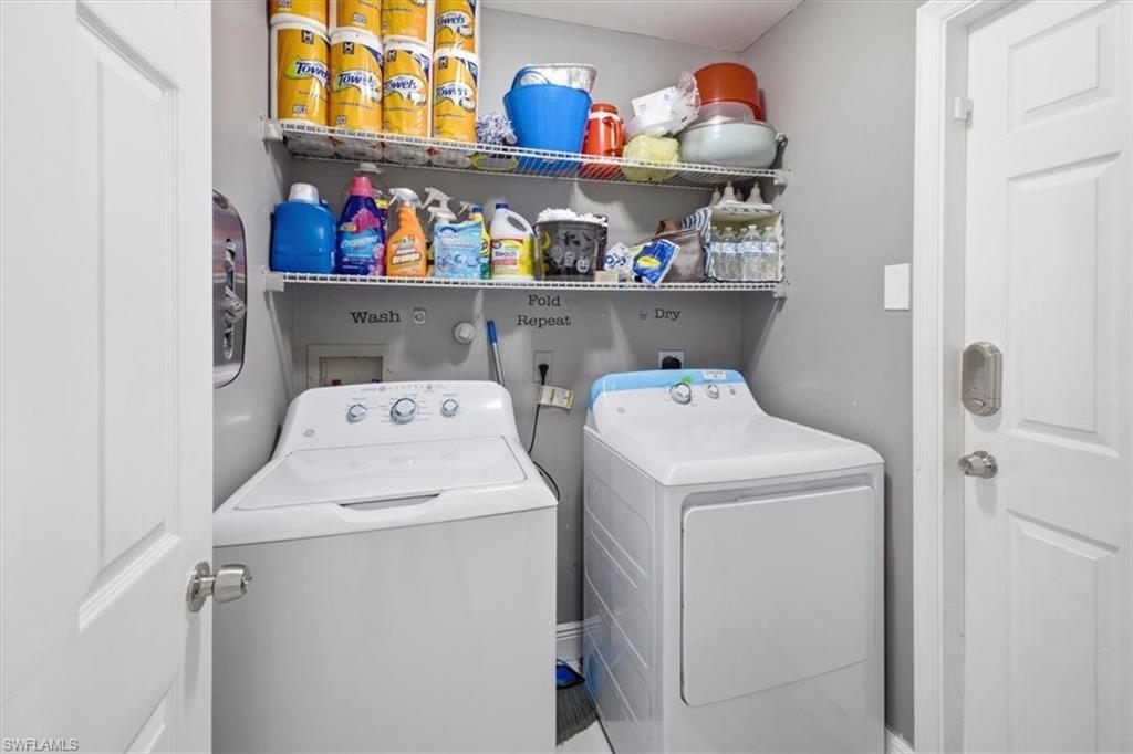 Dedicated laundry area featuring a washer and dryer, painted walls, and built-in wire shelving