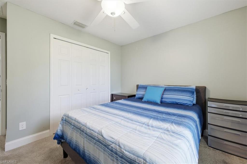 Wall-to-wall carpeting and a ceiling fan with integrated lighting