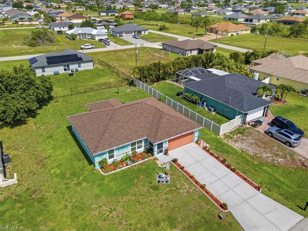 Single-story home featuring a teal exterior and a brown shingle roof