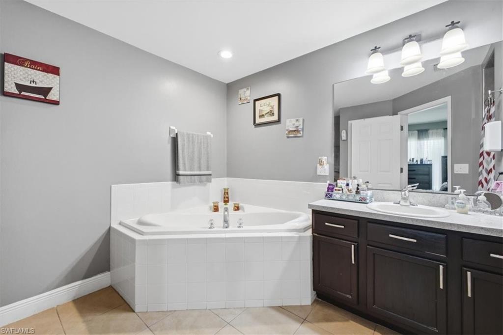 Corner soaking tub with white tile surround