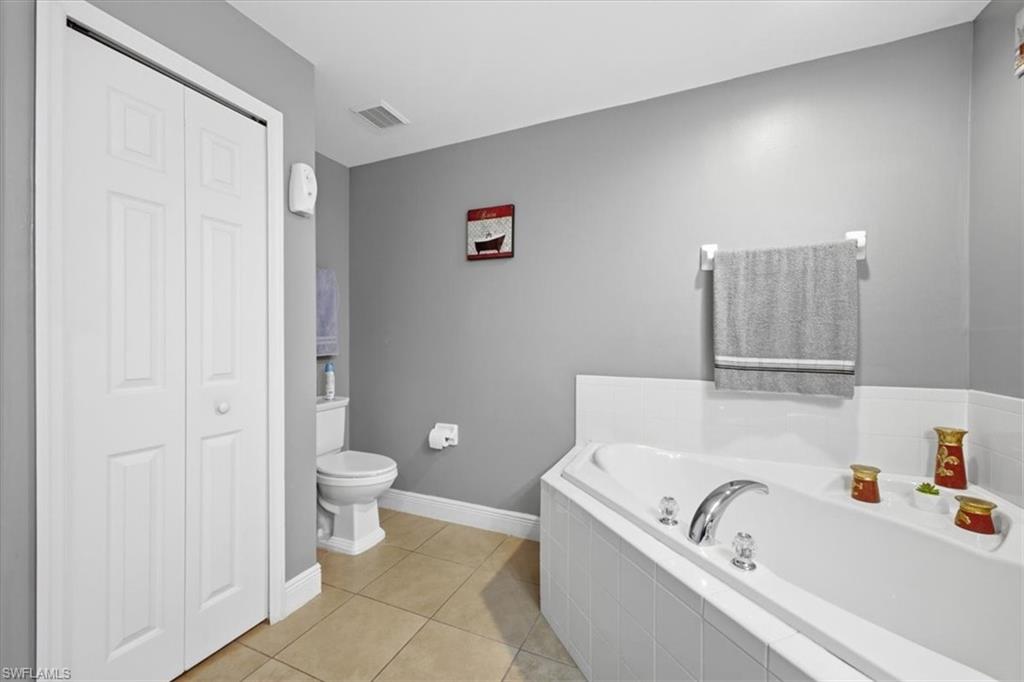 Soaking tub with chrome fixtures and tiled surround