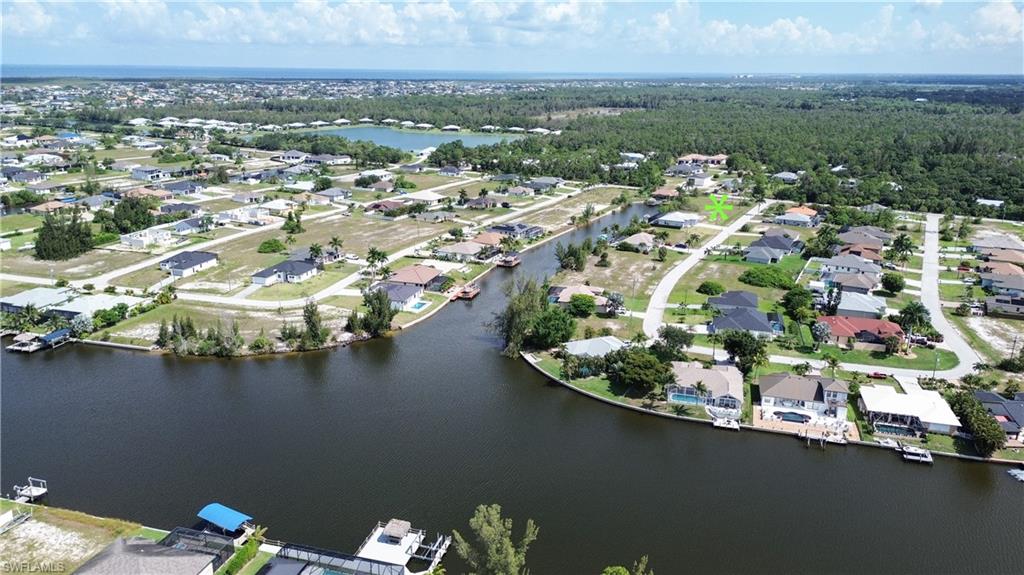 Aerial perspective showcasing a canal-front property within a developed residential area