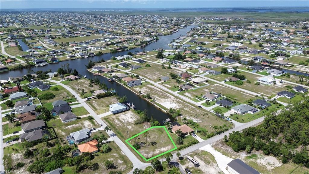 Vacant residential lot outlined in green, situated on a street with established homes