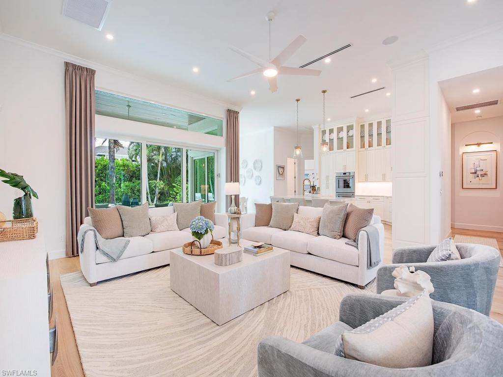 Expansive living area featuring light wood-finish flooring, a large area rug, and recessed ceiling lighting