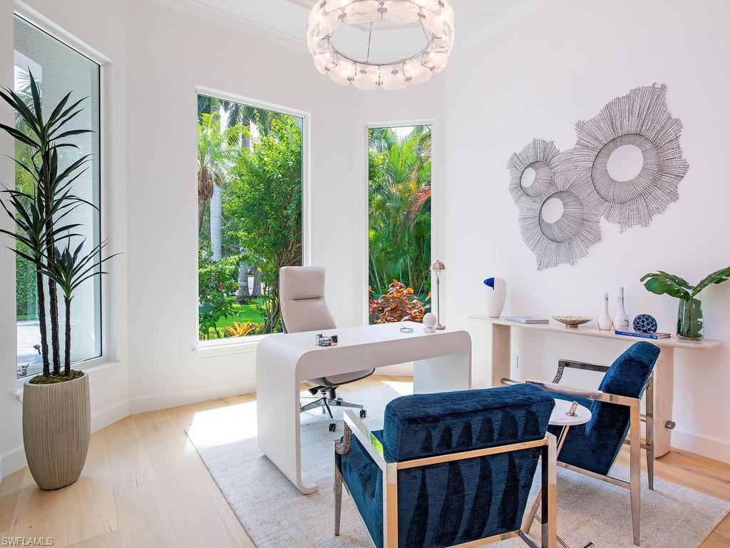 Dedicated room featuring light wood-finish flooring, white walls, and an ornate ceiling fixture