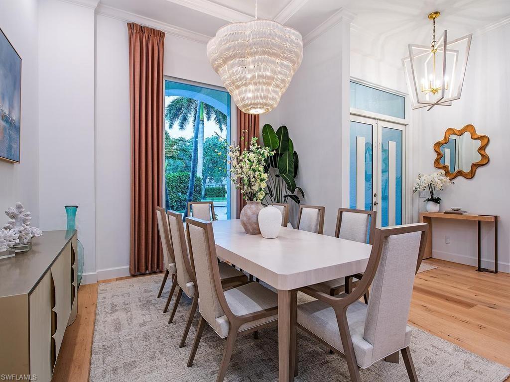 Formal dining space featuring a large sliding glass door, white crown molding, and light wood-finish flooring