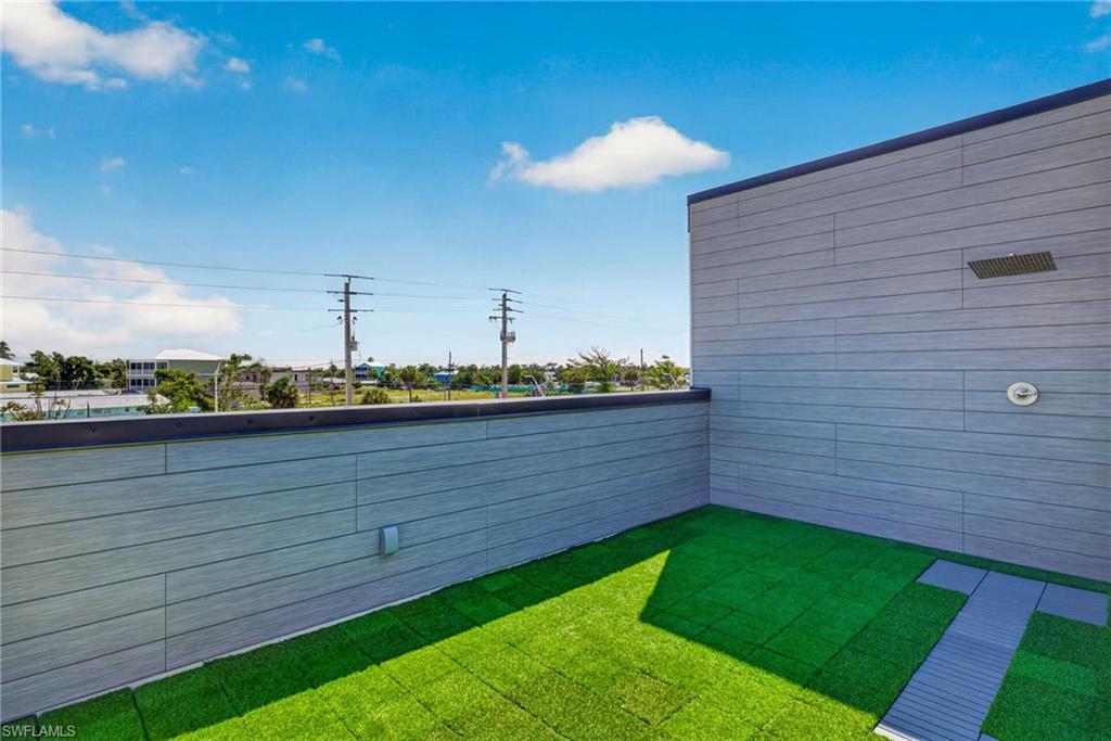 71 Mango Unit 2 Rooftop patio with faux turf flooring and a built-in outdoor shower