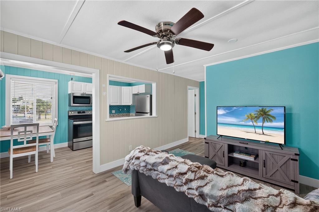 2401 Cottage Ave Unit 1 Open concept living area featuring wood-finish flooring, a ceiling fan, and a pass-through opening to the kitchen