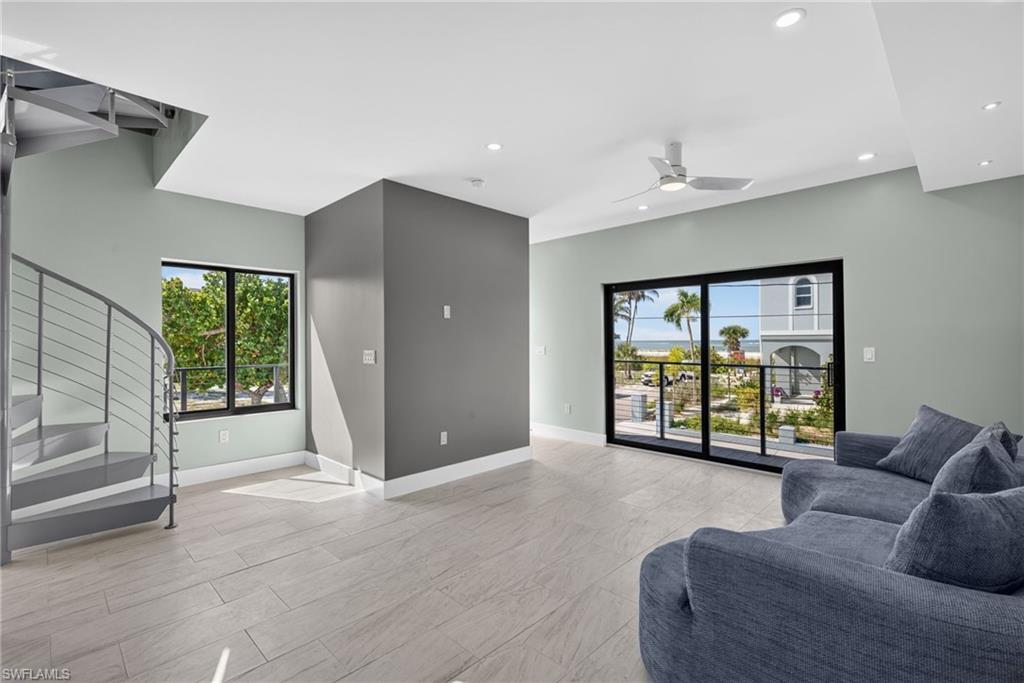 71 Mango Unit 1 Open-concept living area with light-toned flooring, a spiral staircase, and recessed lighting