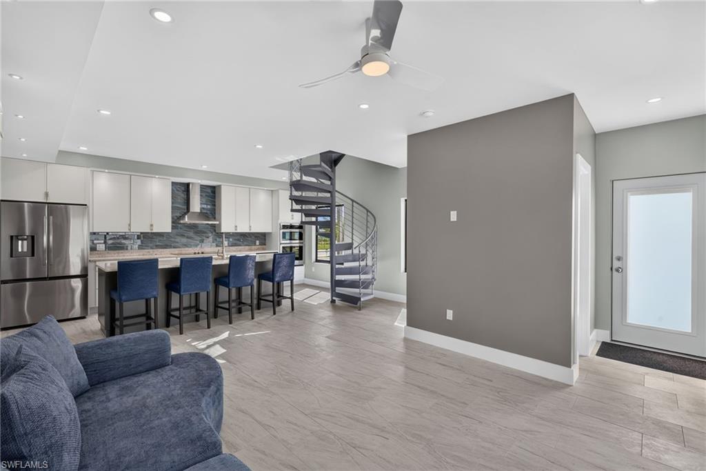 71 Mango Unit 1 Open-concept living area living area featuring a modern kitchen with a large island, stainless steel appliances, and light cabinetry