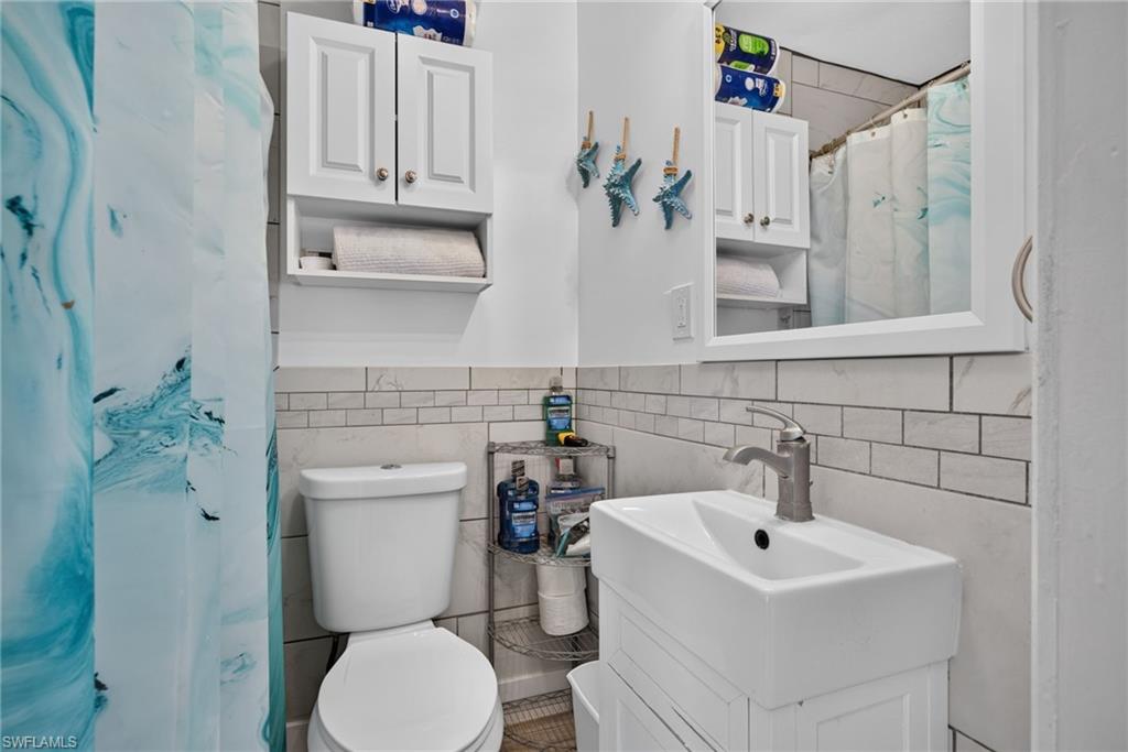 2401 Cottage Ave Unit 2 - Bathroom featuring white subway tile surround, a wall-mounted rectangular basin, and a brushed nickel faucet