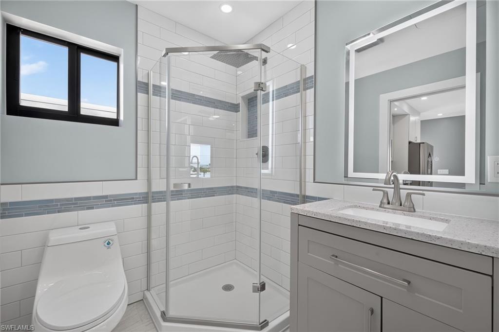 71 Mango Unit 2 bathroom featuring a glass-enclosed shower with subway tile surround and integrated niche