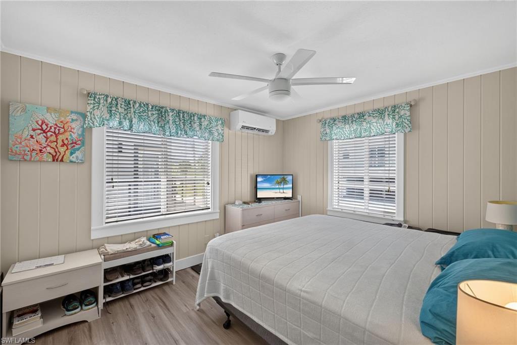 2401 Cottage Ave Unit 2 -  bedroom featuring vertical paneling, two windows with horizontal blinds, and wood-finish flooring