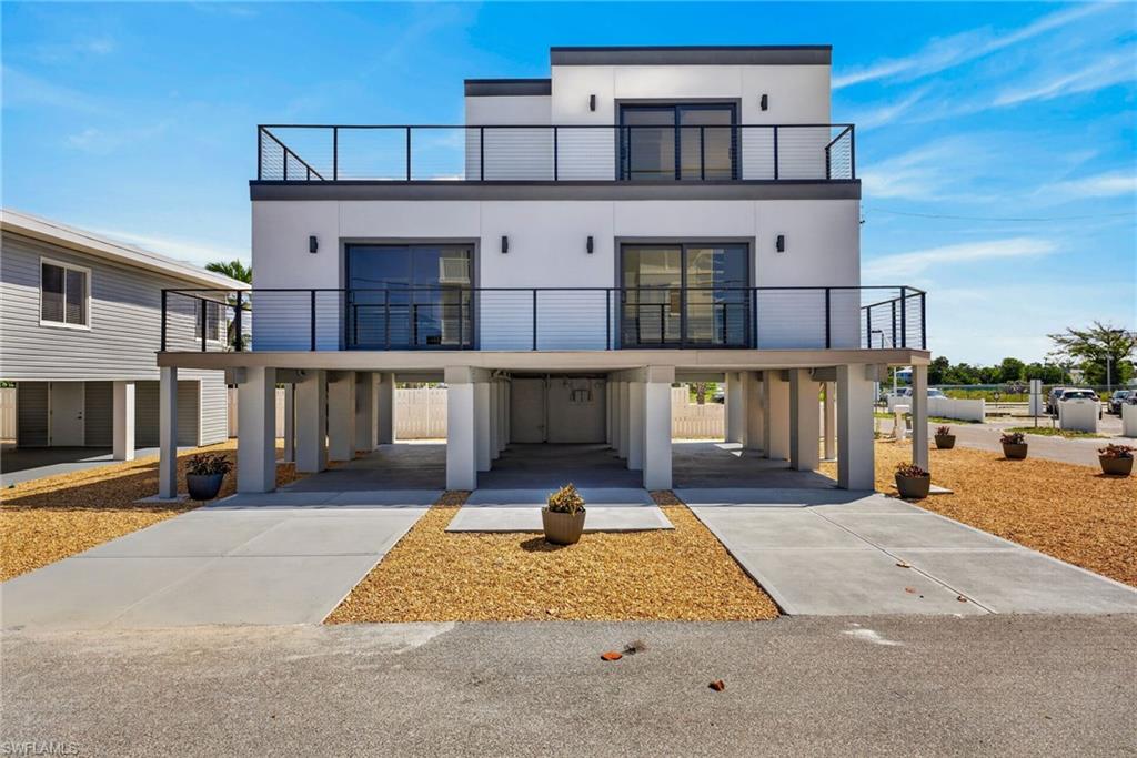 71 Mango - Modern new construction 2 Units 2 beds 2-1/2 baths residence featuring a white stucco exterior and black framed glass doors