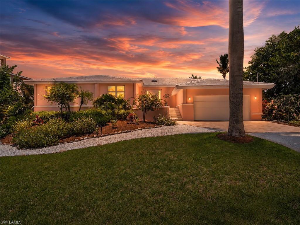 Stunning curb appeal with lush tropical landscaping and a welcoming entry.