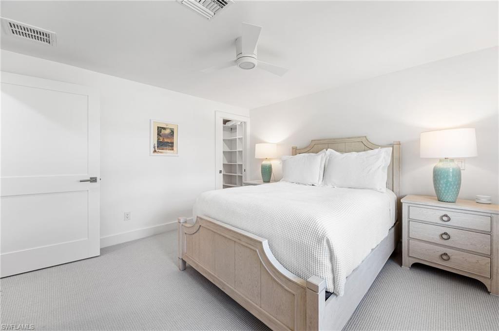 Spacious guest bedroom with natural light and coastal charm.