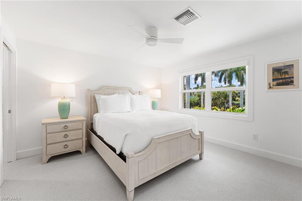 Spacious guest bedroom with natural light and coastal charm.