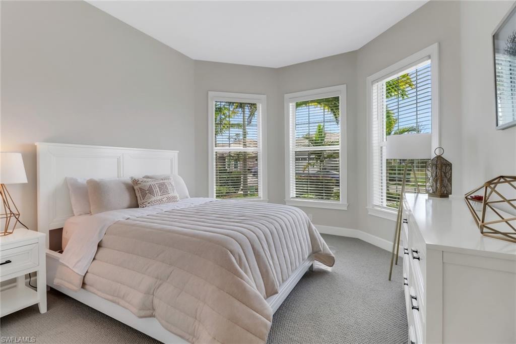 Bedroom with light colored carpet and baseboards
