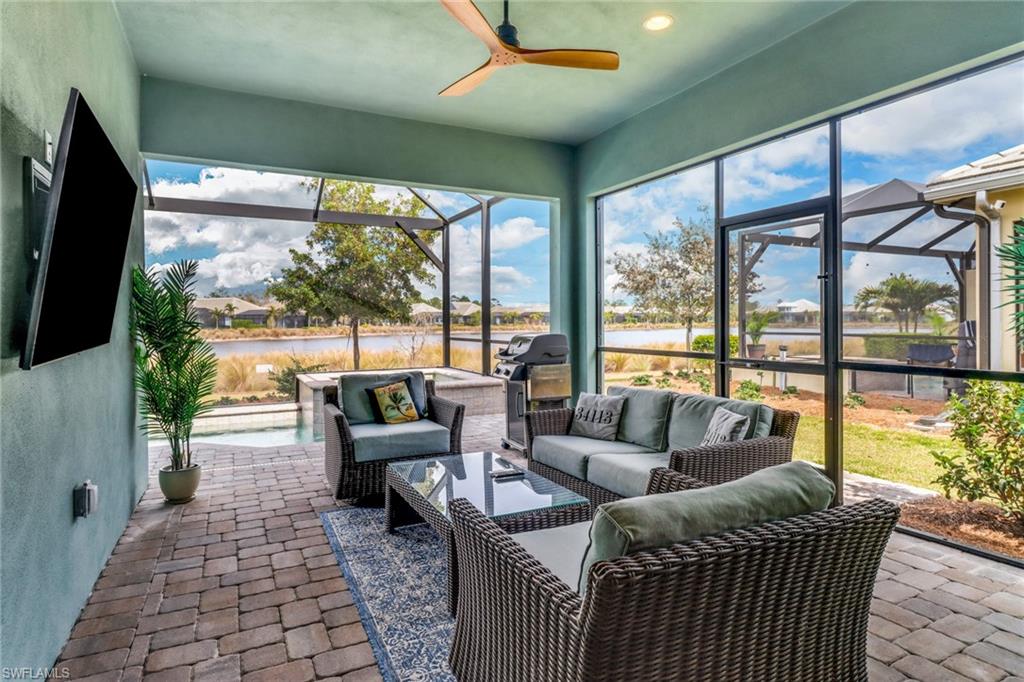 Sunroom / solarium featuring ceiling fan and a water view