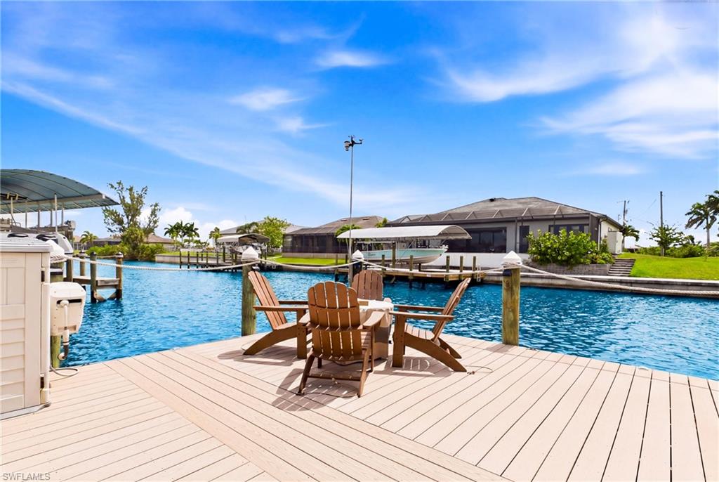 Spacious composite deck with water frontage, featuring a private covered boat lift and dock pilings