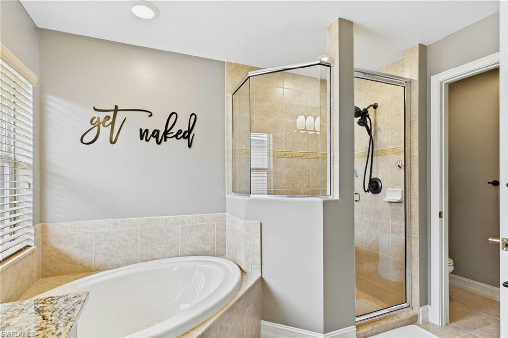 Recessed soaking tub with surrounding tile and a granite countertop