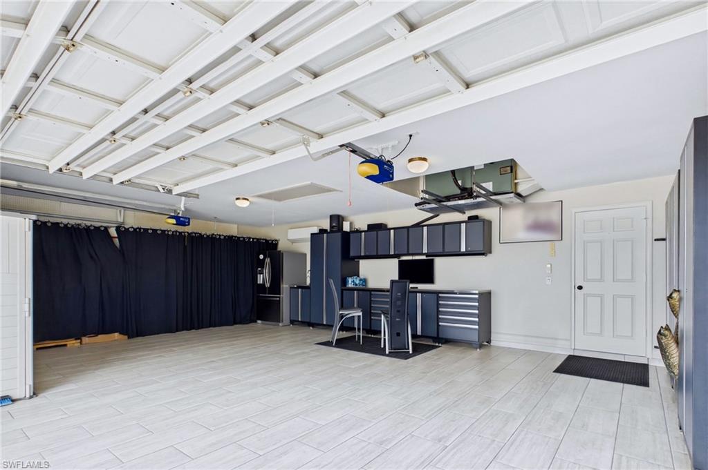 Spacious garage featuring light-toned tile flooring and organized storage solutions