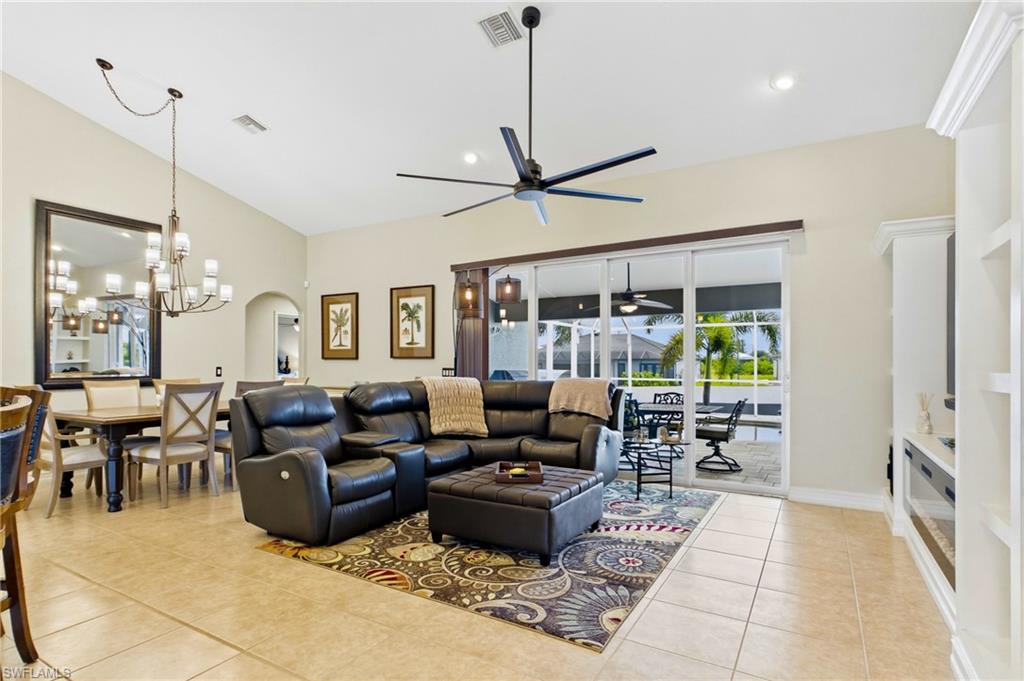 Spacious open-concept living area featuring high vaulted ceilings and light-toned tile flooring