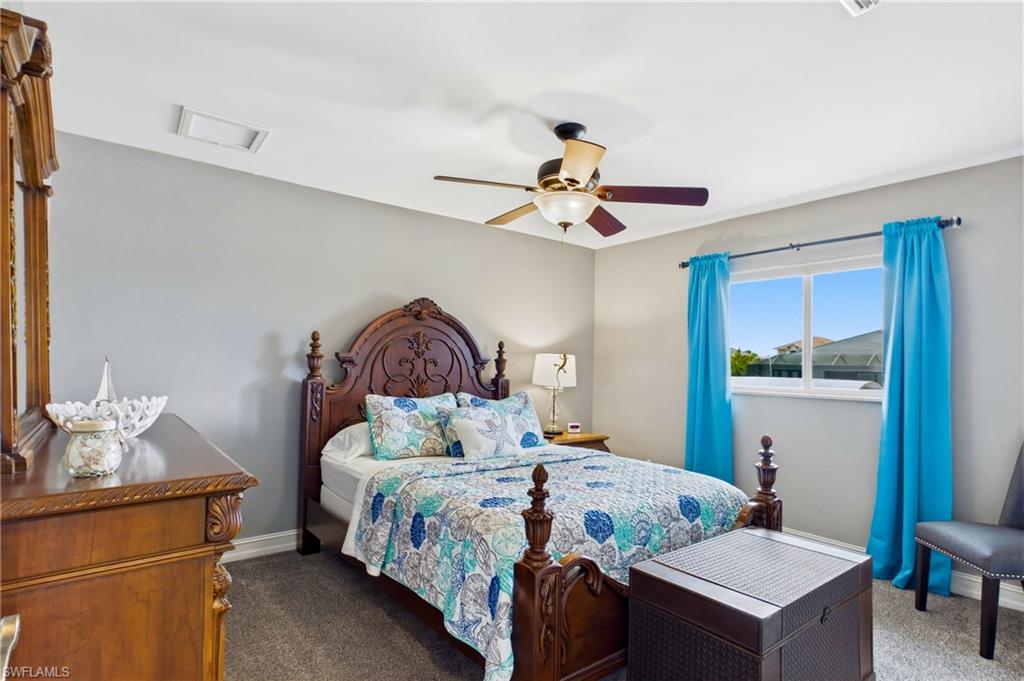 Interior room featuring light gray walls, a window with natural light, and a ceiling fan with integrated lighting