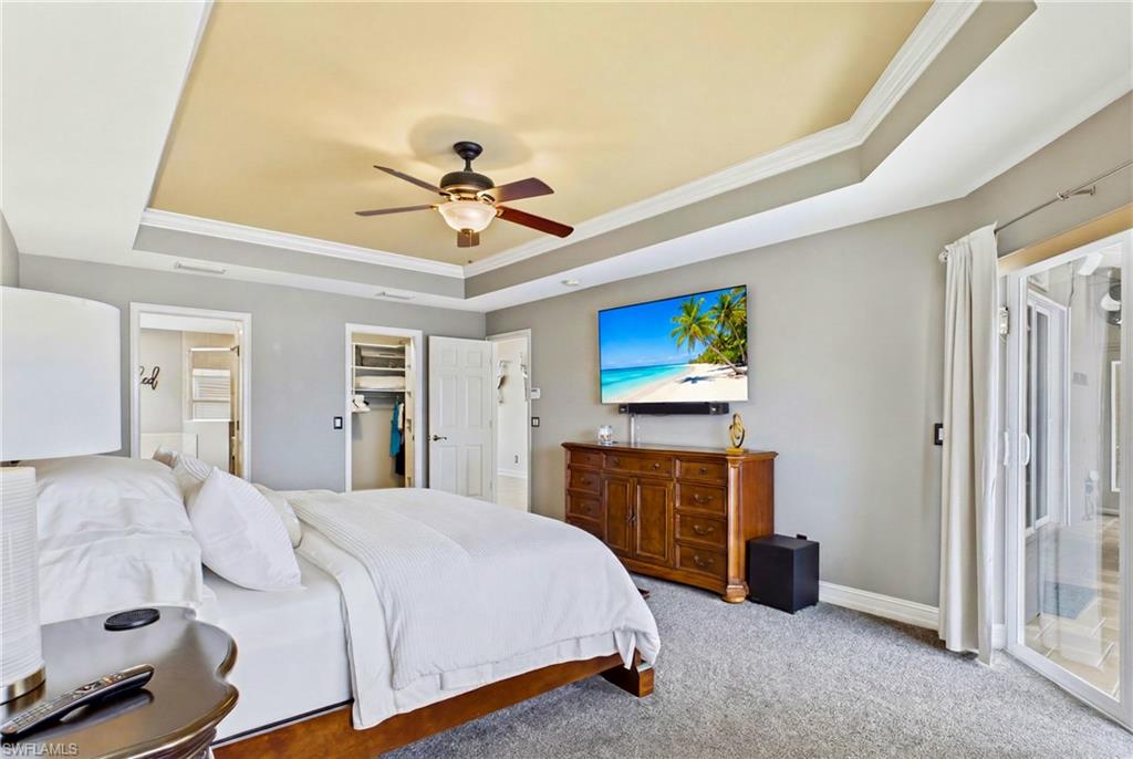 Recessed ceiling with crown molding, ceiling fan, and light gray wall paint
